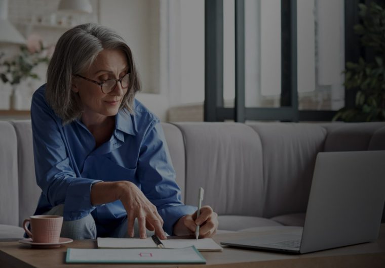 woman writing down in her notes in a living room