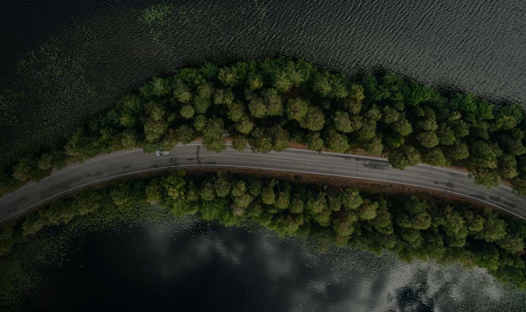 A background image for EV Universe of a car driving on an empty road.