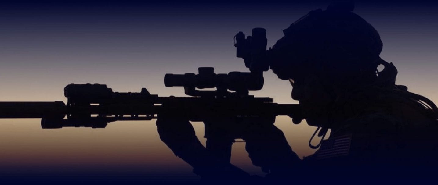 A man looks down the visor of his gun