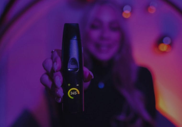 A woman holds a vape to camera