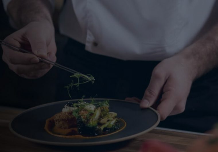 A background image for Ventura Foods of a chef preparing a meal