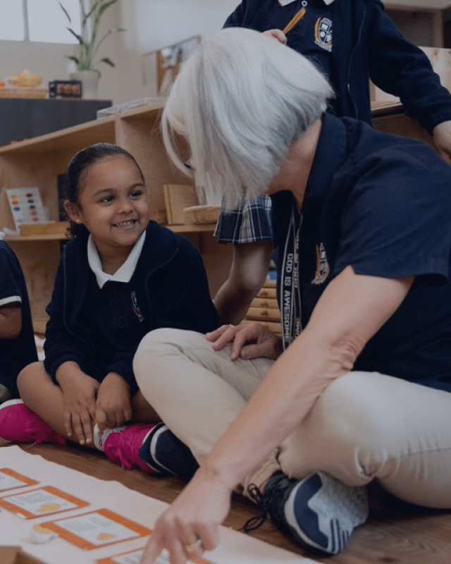 A child smiles at her teacher in school